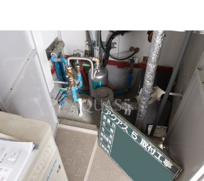 パイプシャフト内の水道メーター器の後ろに置いたアクアス５のセントラル浄水器と給水配管